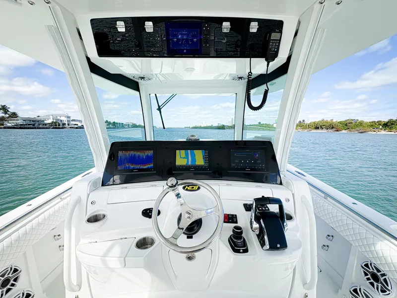 Slide: The Image of 2023 HCB 39 Speciale boat cockpit with advanced navigation system and scenic water view. - 18