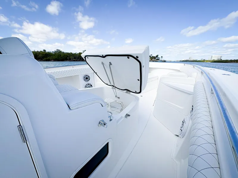 Slide: The Image of 2023 HCB 39 Speciale boat interior with open storage compartment, sleek white design, and blue sky. - 30