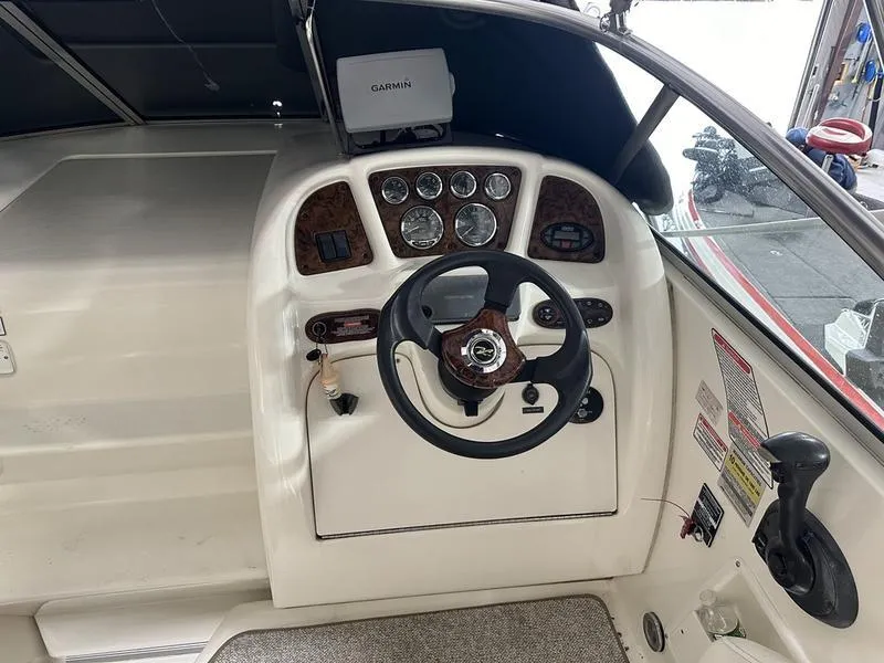 Slide: The Image of 2004 Sea Ray 260 Sundancer cabin interior with cozy seating and wooden table. - 8