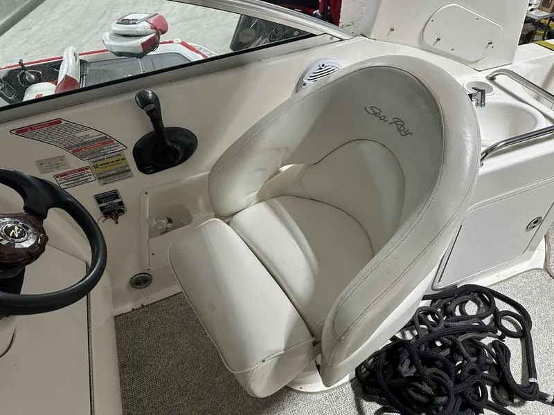 Slide: The Image of 2004 Sea Ray 260 Sundancer interior with white seating and dashboard. - 9