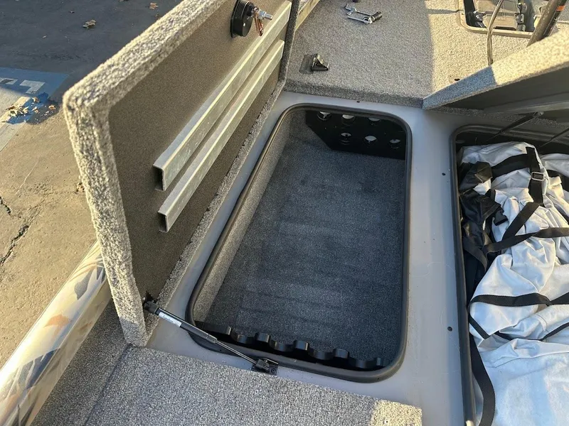Slide: The Image of 2024 Ranger RT188P boat storage compartment with open lid, showing interior space. - 27