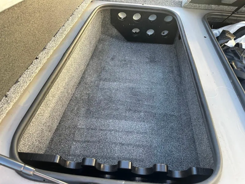 Slide: The Image of 2024 Ranger RT188P boat storage compartment with rod holders, carpeted interior. - 28