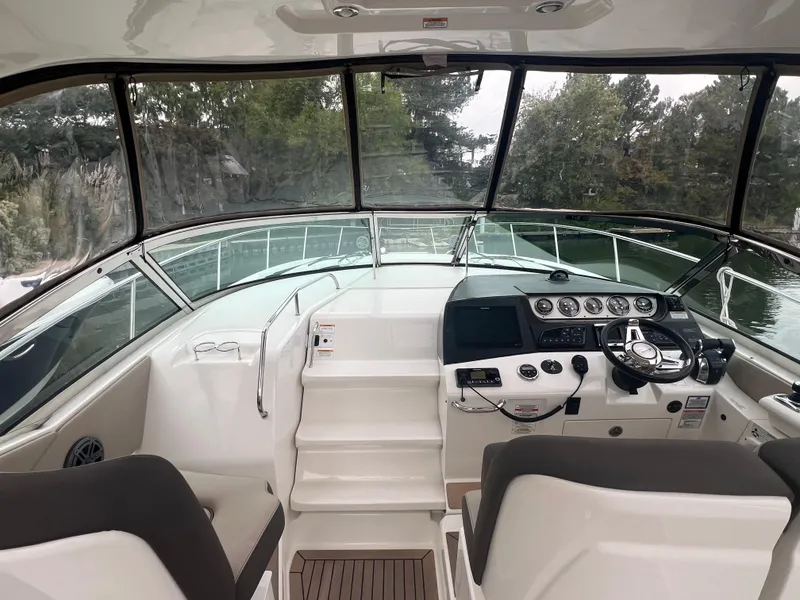 Slide: The Image of 2016 Sea Ray 370 Sundancer helm with modern controls and panoramic view. - 17
