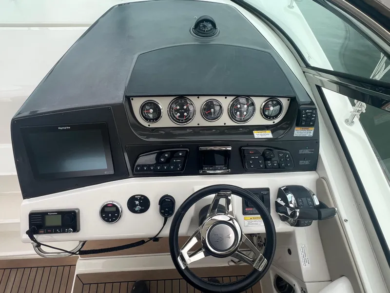 Slide: The Image of 2016 Sea Ray 370 Sundancer helm with modern controls and navigation display. - 18