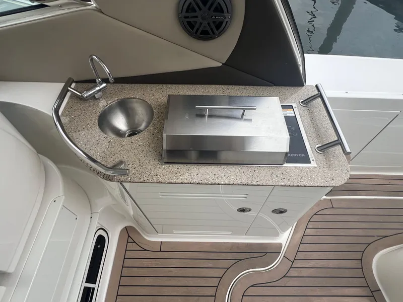 Slide: The Image of 2016 Sea Ray 370 Sundancer boat kitchenette with sink and grill on deck. - 19