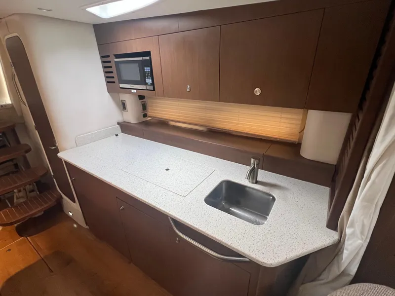 Slide: The Image of Modern kitchen area in 2016 Sea Ray 370 Sundancer yacht with sleek cabinetry and appliances. - 24