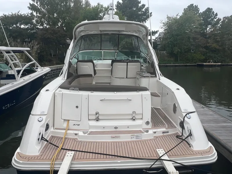 Slide: The Image of 2016 Sea Ray 370 Sundancer docked, rear view, with spacious deck and seating. - 30