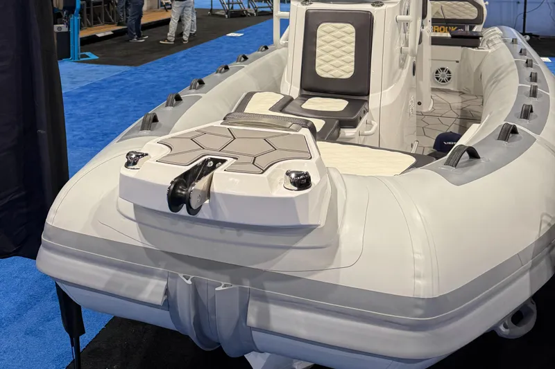 Slide: The Image of 2025 Highfield Sport 560 boat displayed on blue carpet at a show. - 11