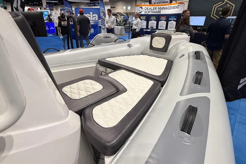 Slide: The Image of 2025 Highfield Sport 560 boat interior with cushioned seating at a trade show. - 9