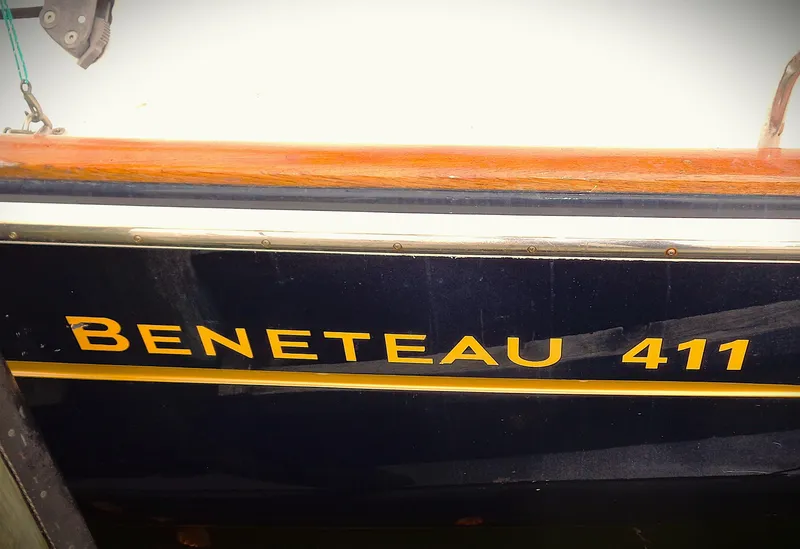 Slide: The Image of 2002 Beneteau 411 sailboat with wooden trim and model name displayed. - 1