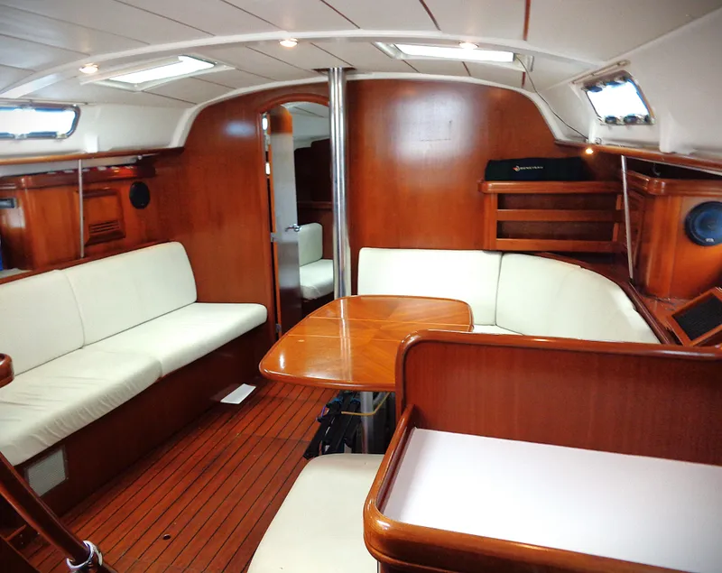 Slide: The Image of Interior of 2002 Beneteau 411 yacht with wooden finish and white seating. - 2