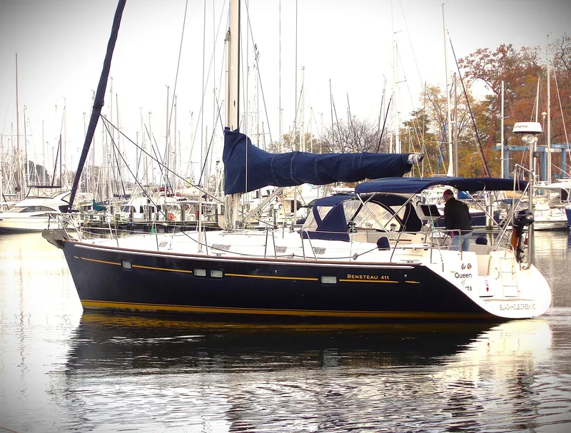 Slide: The Image of 2002 Beneteau 411 sailboat docked in a marina, surrounded by other boats. - 22