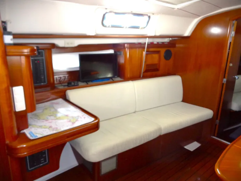 Slide: The Image of Interior of 2002 Beneteau 411 yacht with wooden finish and white seating. - 7