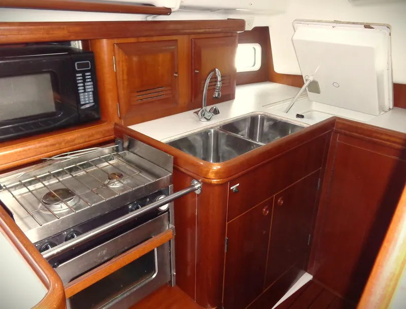 Slide: The Image of 2002 Beneteau 411 yacht kitchen with stove, sink, and microwave. - 8