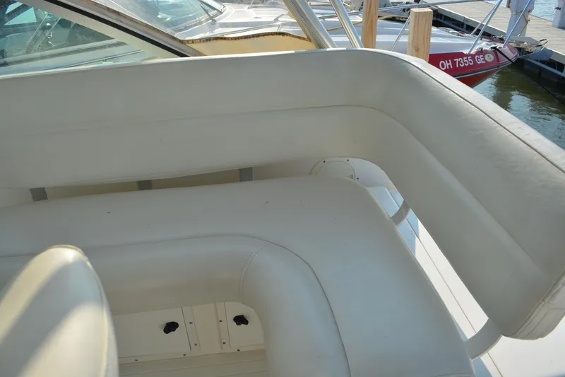 Slide: The Image of White leather seating on a 1999 Pursuit 3400 Express boat at a marina. - 10