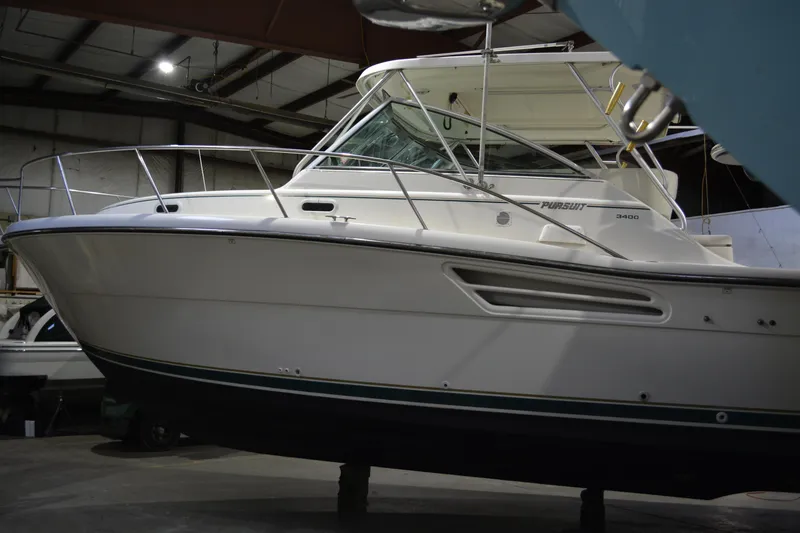 Slide: The Image of 1999 Pursuit 3400 Express boat in indoor storage facility. - 15