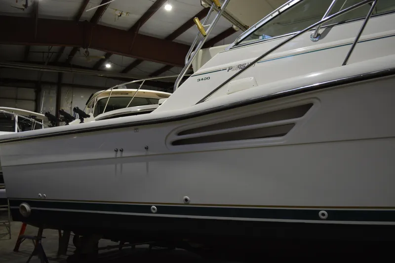 Slide: The Image of 1999 Pursuit 3400 Express boat in indoor storage facility. - 18