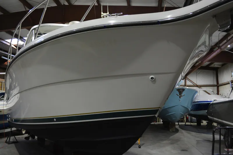 Slide: The Image of 1999 Pursuit 3400 Express boat in indoor storage facility. - 19