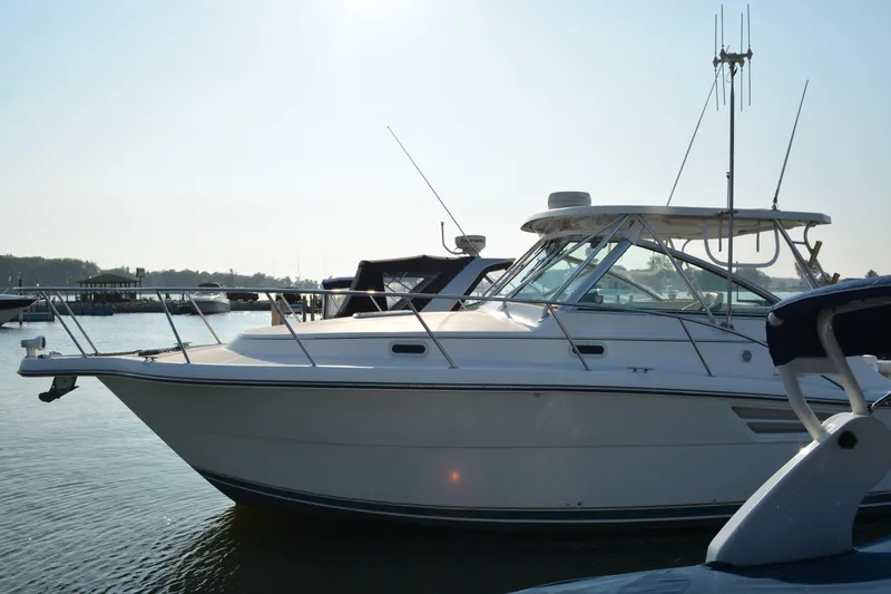 Slide: The Image of 1999 Pursuit 3400 Express boat docked in a marina under clear skies. - 2