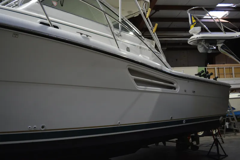 Slide: The Image of 1999 Pursuit 3400 Express boat in indoor storage facility. - 22