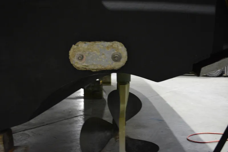 Slide: The Image of 1999 Pursuit 3400 Express boat propeller and zinc anode in a garage. - 24