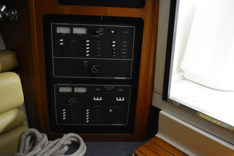 Slide: The Image of Interior of 1999 Pursuit 3400 Express boat with wood paneling and beige seating. - 26