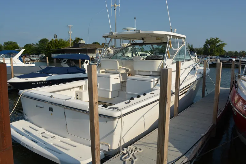 Slide: The Image of 1999 Pursuit 3400 Express boat docked at marina, featuring spacious deck and sleek design. - 4