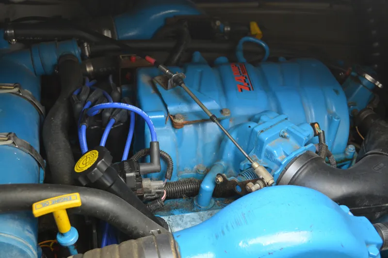Slide: The Image of Engine of a 1999 Pursuit 3400 Express boat, featuring blue components and wiring. - 46
