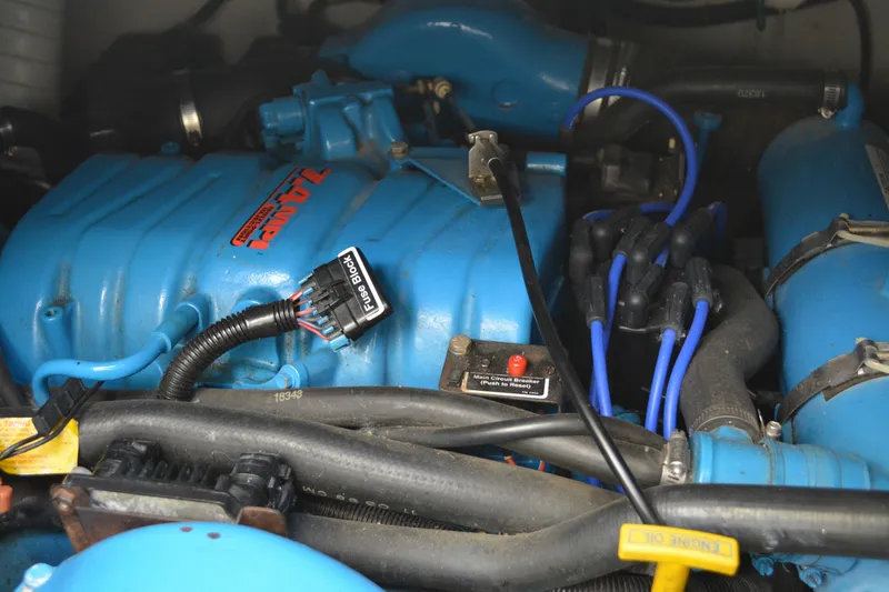 Slide: The Image of Engine compartment of a 1999 Pursuit 3400 Express boat, featuring blue components and wiring. - 49
