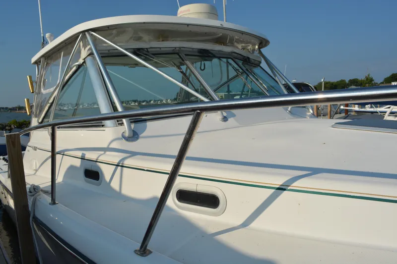 Slide: The Image of 1999 Pursuit 3400 Express boat docked under clear blue sky. - 5