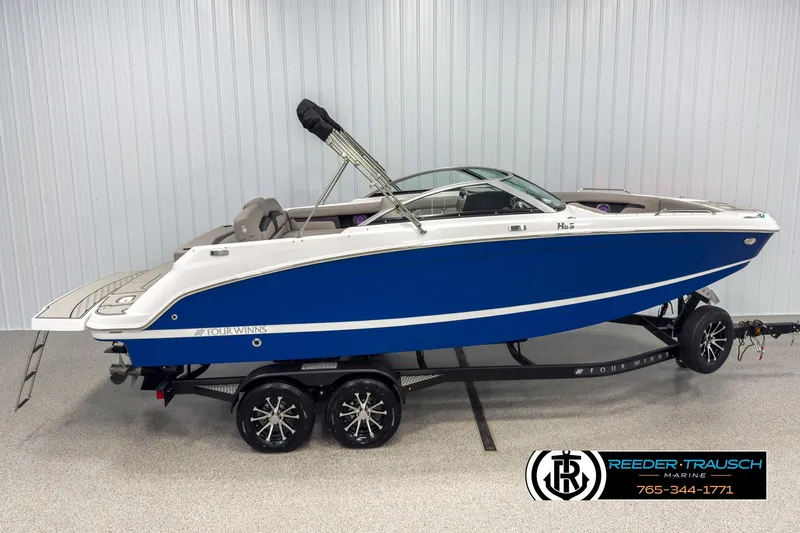 The Image of 2025 Four Winns HD3 boat in blue on trailer, displayed indoors. - 1