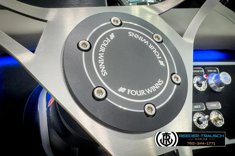 Slide: The Image of Steering wheel of 2025 Four Winns HD3 boat with control panel details. - 31