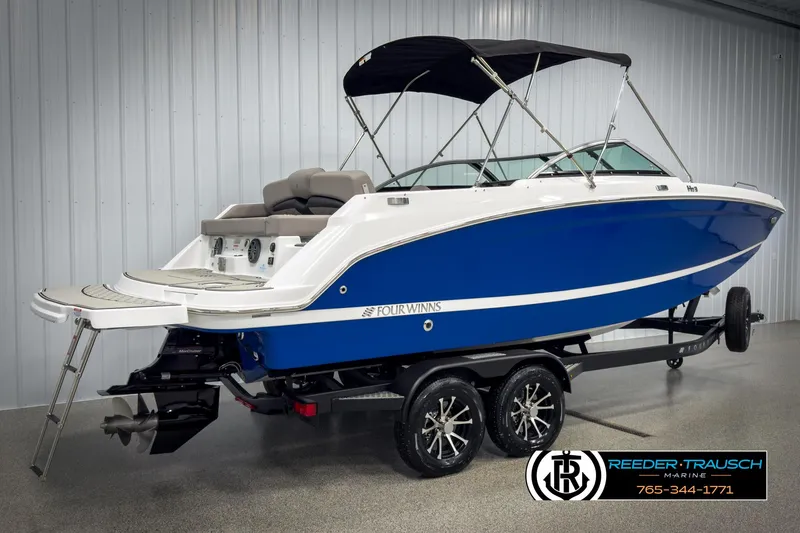Slide: The Image of 2025 Four Winns HD3 boat with blue hull on trailer, displayed indoors. - 6