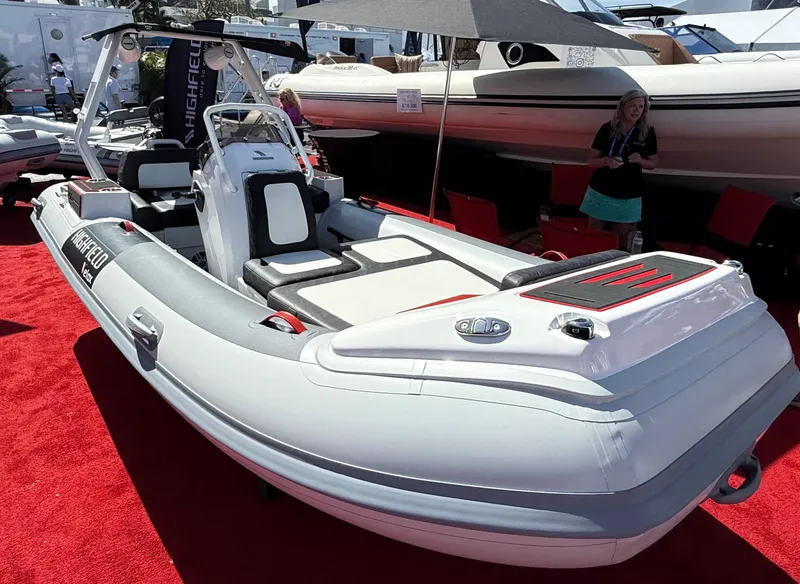 Slide: The Image of 2025 Highfield Velox 420 boat displayed on red carpet at a boat show. - 2