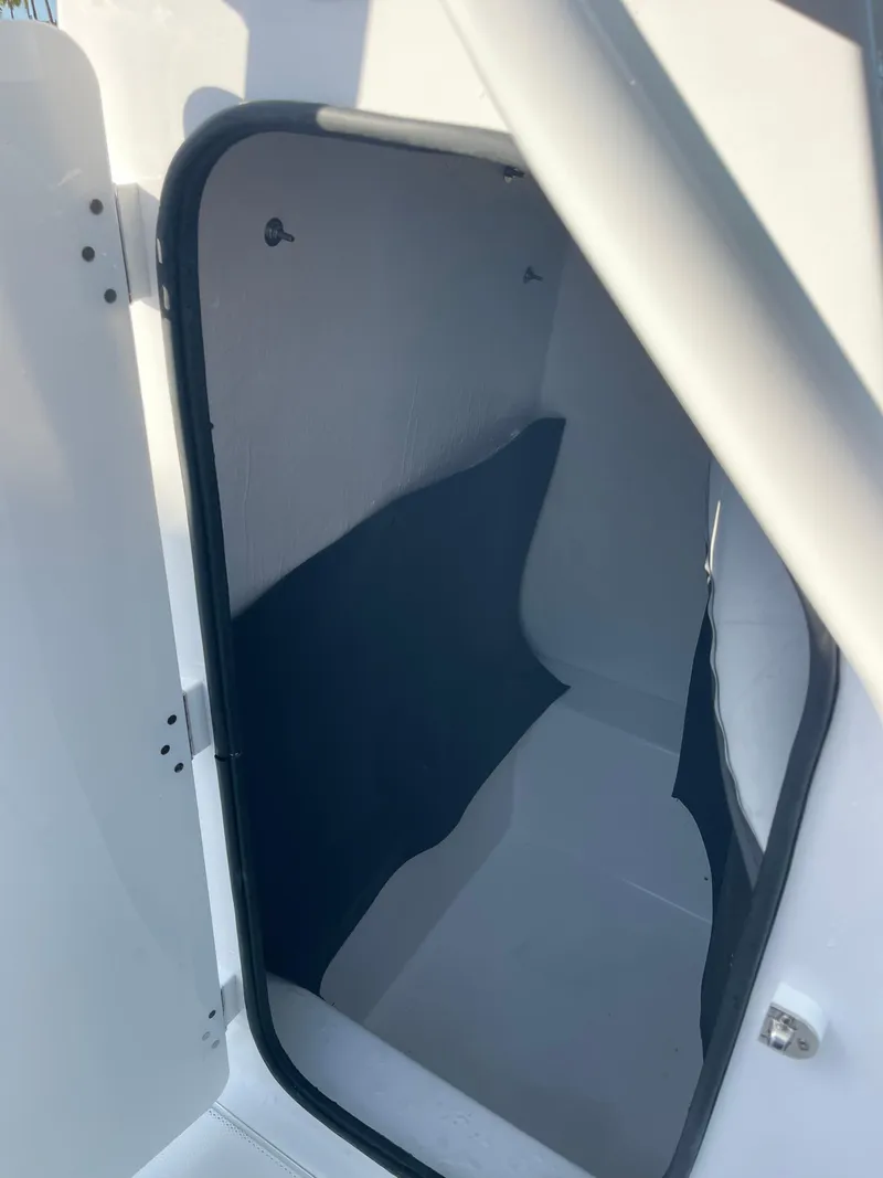 Slide: The Image of 2025 Clearwater 2200 WI Center Console storage compartment, open door view. - 13