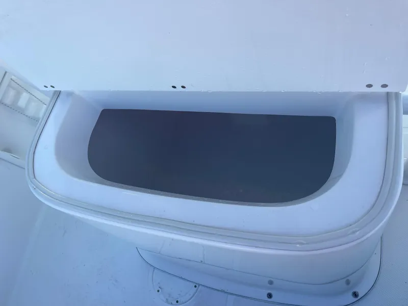 Slide: The Image of Clearwater 2200 WI Center Console 2025 boat storage compartment, open and empty. - 19