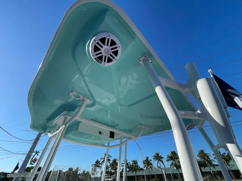Slide: The Image of 2025 Clearwater 2200 WI Center Console boat, turquoise canopy, speaker, clear sky background. - 21
