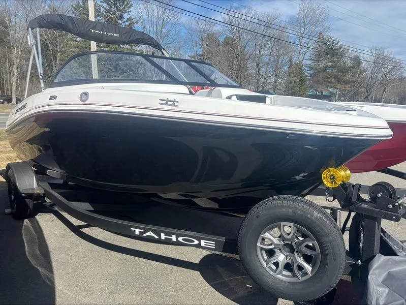 Slide: The Image of 2025 Tahoe 185 S boat on trailer, black and white design, parked outdoors. - 0