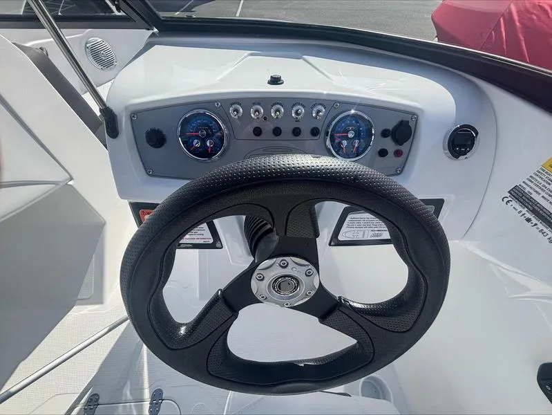 Slide: The Image of Steering wheel and dashboard of 2025 Tahoe 185 S boat, featuring modern controls and gauges. - 12