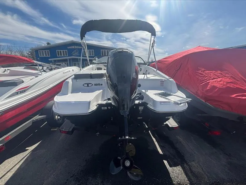 Slide: The Image of 2025 Tahoe 185 S boat with outboard motor, parked outdoors under a clear sky. - 8