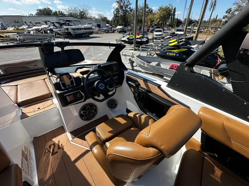 Slide: The Image of 2022 Axis A24 boat interior with brown leather seats and modern dashboard. - 14