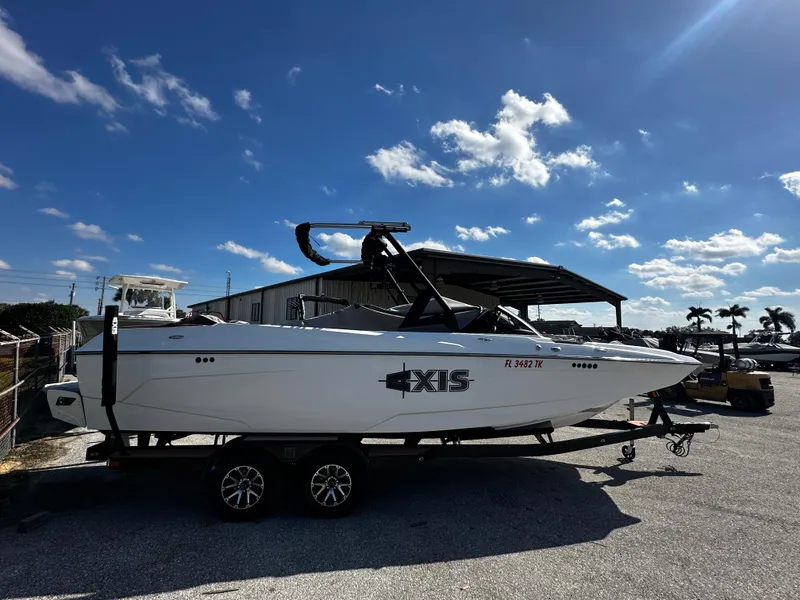 Slide: The Image of 2022 Axis A24 boat on trailer under clear blue sky. - 2