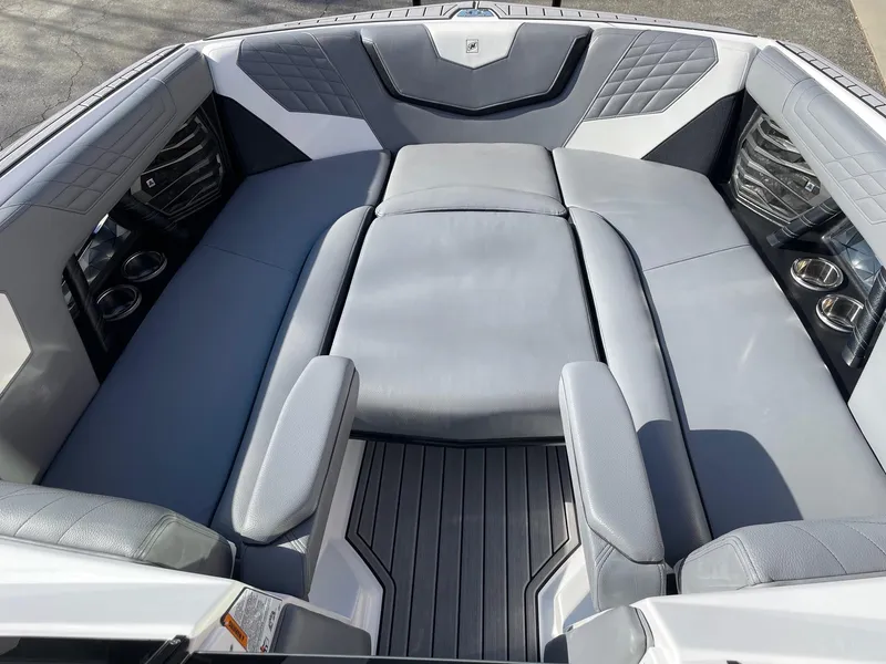 Slide: The Image of 2022 Nautique Super Air Nautique G25 boat interior with gray seating and cup holders. - 11