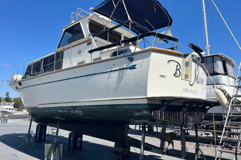 Slide: The Image of 1985 Roughwater 41 Pilothouse boat on stands, undergoing maintenance at a marina. - 17