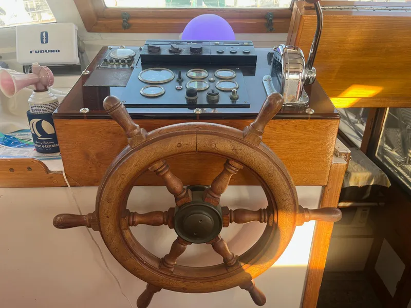 Slide: The Image of Wooden helm and control panel of 1985 Roughwater 41 Pilothouse boat. - 2