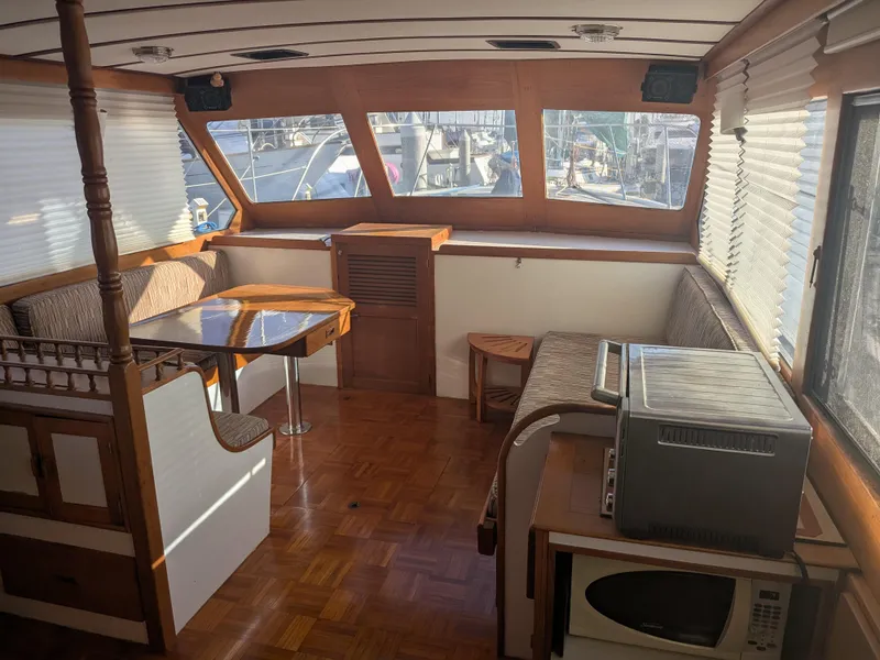 Slide: The Image of Interior of 1985 Roughwater 41 Pilothouse with dining area and kitchen appliances. - 9