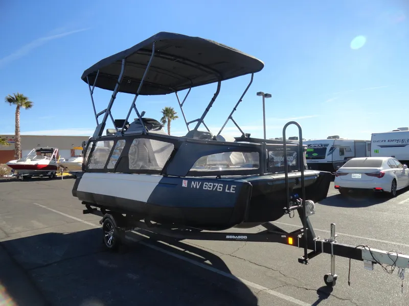 Slide: The Image of 2024 Sea-Doo Switch Sport 18 - 230 HP pontoon boat on trailer in parking lot. - 4