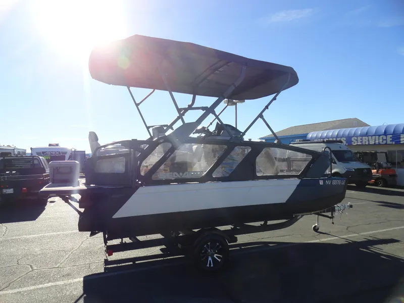 Slide: The Image of 2024 Sea-Doo Switch Sport 18 - 230 HP boat with canopy in a sunny outdoor setting. - 5