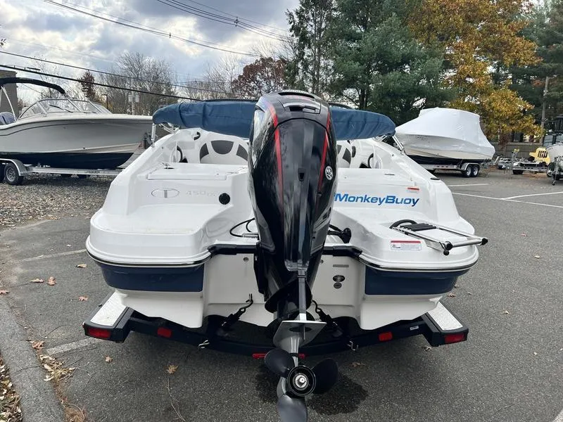 Slide: The Image of 2021 Tahoe 450 TS boat with outboard motor in parking lot. - 6