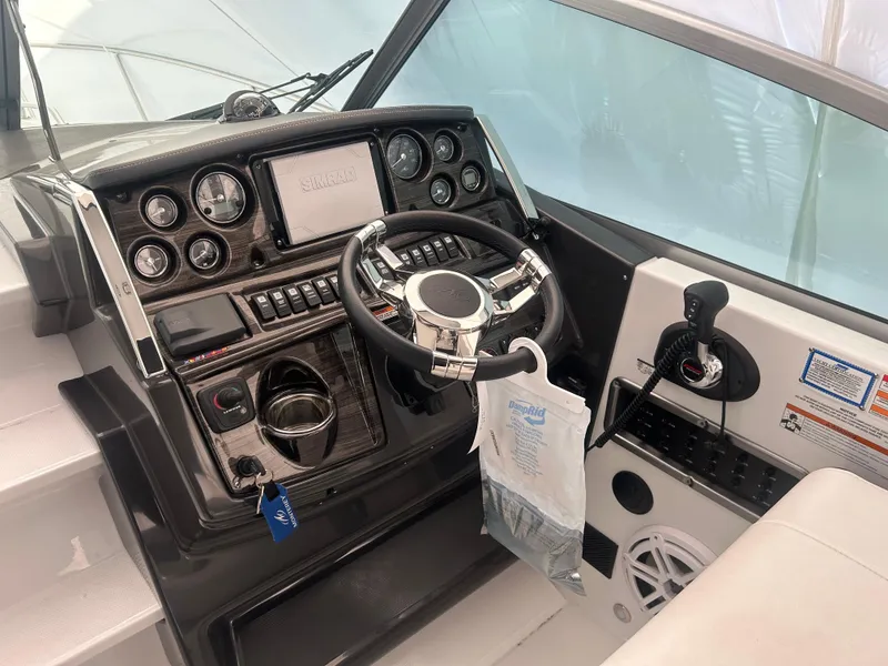 Slide: The Image of 2022 Monterey 295 Sport Yacht dashboard with steering wheel and control panel. - 11